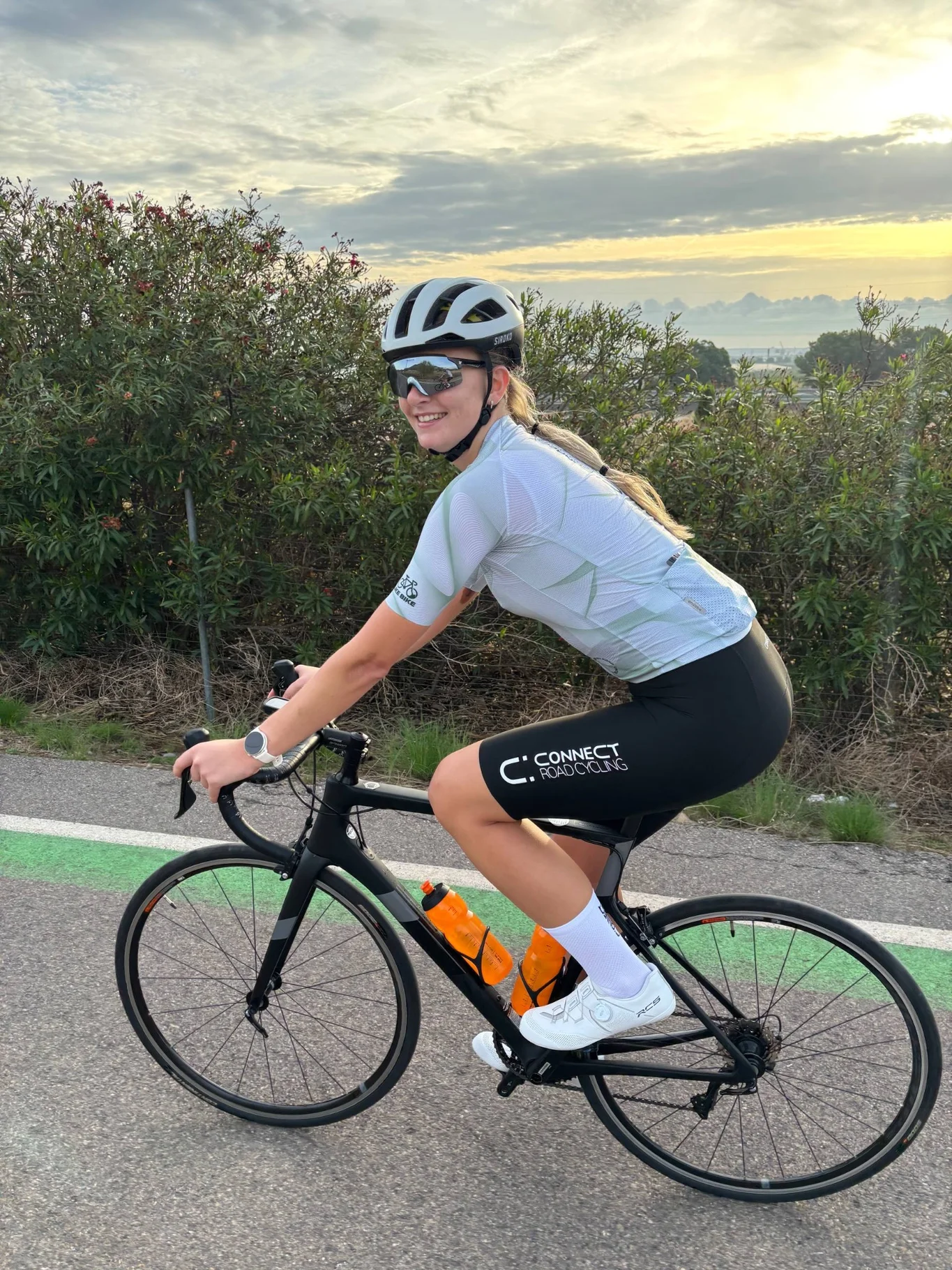 Cyclist wearing CONNECT Road Cycling branded bib shorts during a club ride.